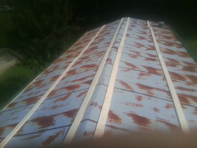 Rusted metal roof panels with new wood purlins before replacement — Storm Damage Roof Repair in Bellaire by Roofing Brothers