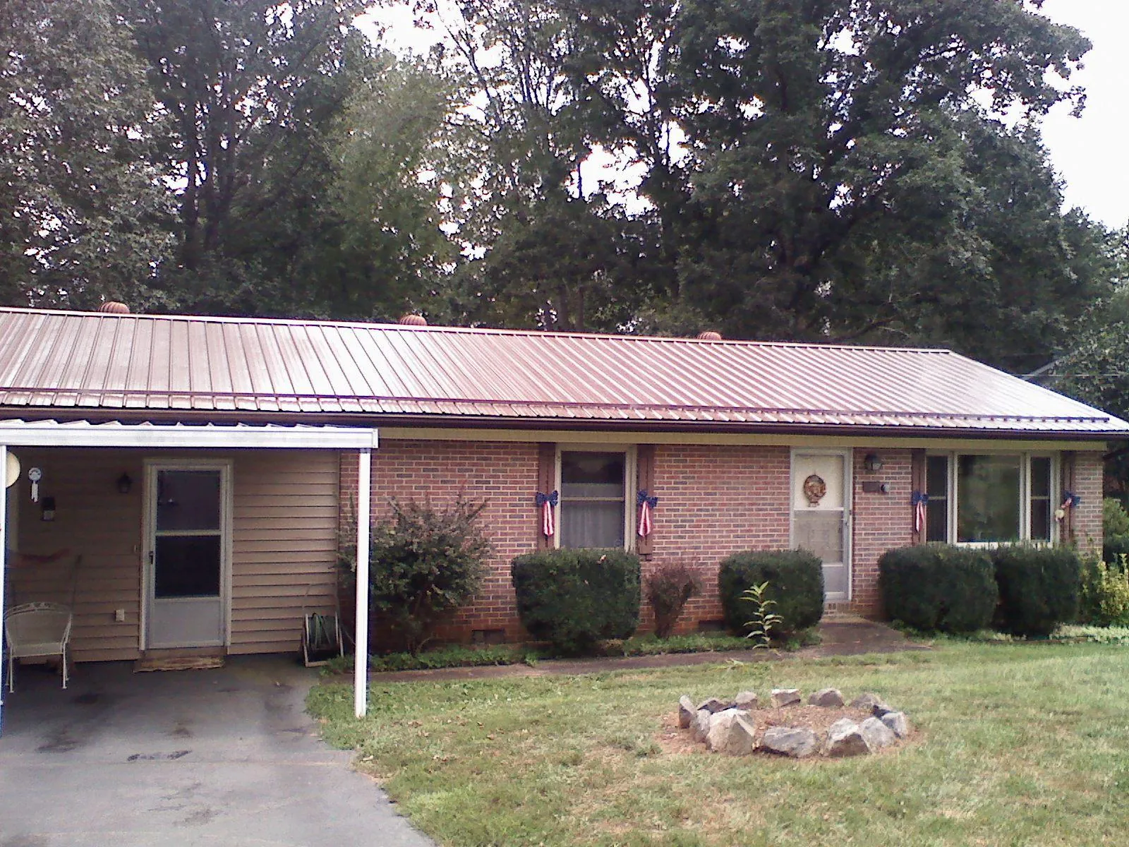 Bronze metal roof and carport on a brick ranch home — Roof Repair work by our crew in Bellaire